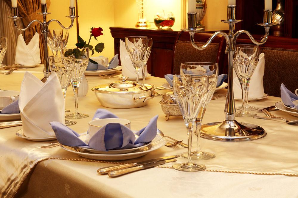 Intercontinental Dar Al Iman Madinah By Ihg Hotel Медина Екстериор снимка The image shows a beautifully arranged dining table set for a formal occasion. The table is covered with a light-colored tablecloth, and the place settings include elegant dinnerware, including plates and crystal glassware. 

Each place setting has f